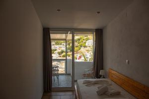 a bedroom with a bed and a view of a balcony at Κastro Ηotel in Agios Kirykos