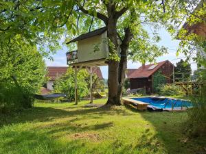 a tree with a tree house on top of it at Öko Wohnung Garten und Pool in Lindau-Bodolz