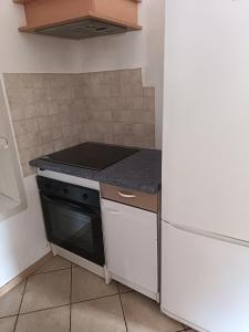 a small kitchen with a stove and a refrigerator at F5 à Montjaux in Montjaux