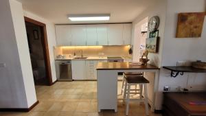 a kitchen with white cabinets and a counter top at Villa Harmony in Charco del Palo