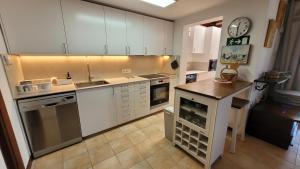 a kitchen with white cabinets and a clock on the wall at Villa Harmony in Charco del Palo +25 photos