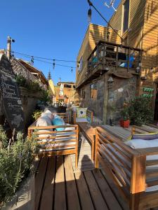 a wooden deck with a bench and a building at Hostal Maitencillo Norte in Maitencillo