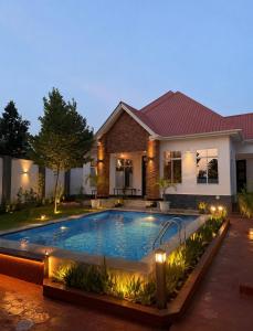 a swimming pool in front of a house at night at The Serenity Hideaway in Arusha