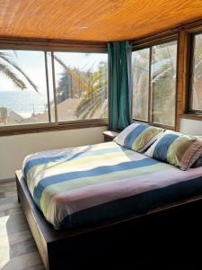 a bedroom with a large bed with a view of the ocean at Hostal Maitencillo Norte in Maitencillo