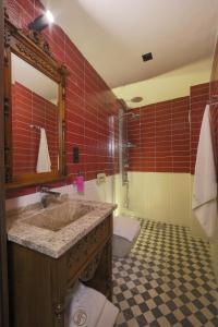 a bathroom with a sink and a toilet and red tiles at Sam Franss Boutique Otel in Hatay +14 photos
