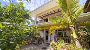 a house with a palm tree in front of it at La Digue Holiday Villa in La Digue