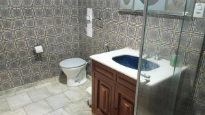 a bathroom with a toilet and a sink at Fenergia Hospedagem Flexível in Pouso Alegre