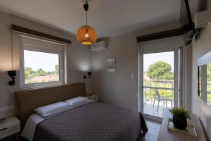 a bedroom with a bed and two windows and a balcony at Marion Apartments in Kourouta +88 photos