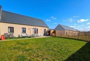 a house with a yard with a fence at La Maison Menhiria in Dol-de-Bretagne