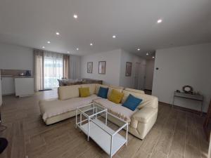 a living room with a white couch and blue pillows at La Maison Menhiria in Dol-de-Bretagne +10 photos