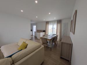 a living room with a couch and a dining room at La Maison Menhiria in Dol-de-Bretagne