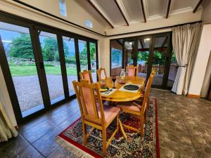 a dining room with a wooden table and chairs at Hogsback Misty Oaks Cottage in Hogsback