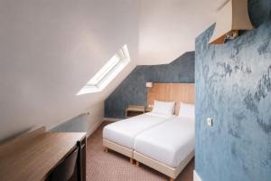 a bedroom with a white bed and a blue wall at Get My Hatch Bergère in Paris