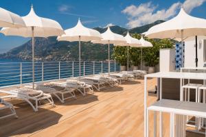 a deck with chairs and umbrellas on a cruise ship at Hotel Club Due Torri in Maiori
