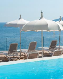 a group of chairs and umbrellas next to a swimming pool at Hotel Club Due Torri in Maiori