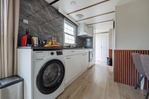 a kitchen with a washing machine in a kitchen at 80, Midden in de natuur - Airco! in Oisterwijk