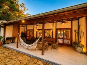 a house with a hammock on a patio at Casa Moderna e Espaçosa com Piscina e Lareira na Serra da Cantareira in Mairiporã