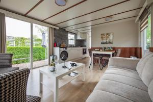 a living room with a couch and a table at 80, Midden in de natuur - Airco! in Oisterwijk