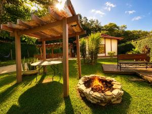 a backyard with a fire pit and a pergola at Casa Moderna e Espaçosa com Piscina e Lareira na Serra da Cantareira in Mairiporã