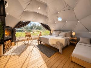 a bedroom in a tent with a bed and a fireplace at Trysil Glamping in Trysil
