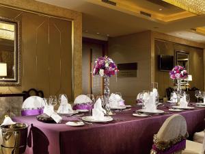 a long purple table with chairs and flowers on it at Sofitel Harbin in Harbin