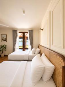 two beds in a hotel room with white pillows at Aradhana by Nepali in Moratuwa