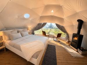 a bedroom with a bed and a fireplace in a tent at Trysil Glamping in Trysil
