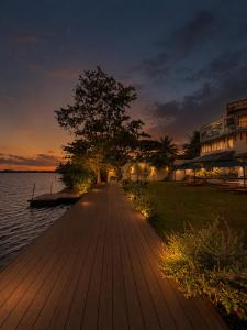 a wooden pathway next to the water at night at Aradhana by Nepali in Moratuwa