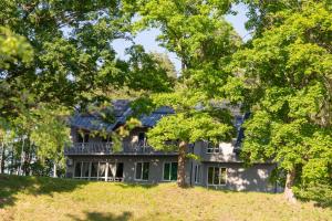 a large house on a hill with trees at Orinoko Guest House in Stacija Sece