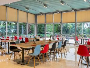 a large room with tables and chairs and windows at Ibis Gaziantep in Gaziantep