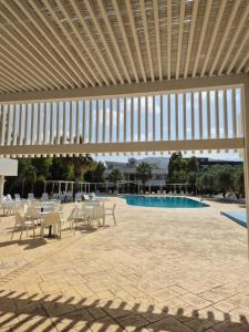 a patio with tables and chairs and a pool at Hsdominicus in Cirella +5 photos