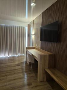 a room with a desk with a television on a wall at Hsdominicus in Cirella