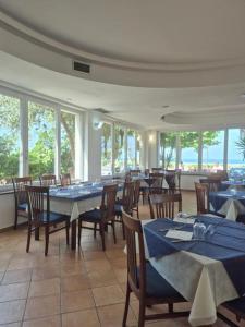 a dining room with tables and chairs and windows at Hsdominicus in Cirella