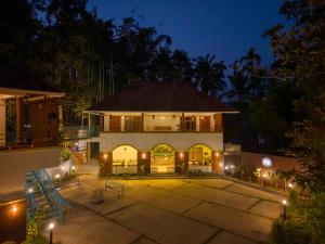 a large house with a courtyard at night at Swastha Royals Wayanad in Kaniyāmbetta