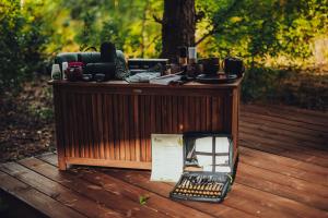 a wooden table on a wooden deck with a camera at Dacza Puchacza Hamaki in Stare Osieczno