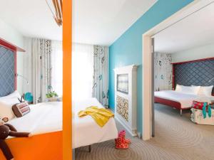 a bedroom with two beds and a mirror at ibis Styles Hotel Berlin Mitte in Berlin