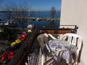 a balcony with two chairs and a table and flowers at Affittacamere Porticciolo in Castelnuovo del Garda