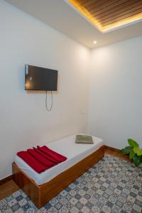 a room with a bed with a flat screen tv on the wall at Swastha Royals Wayanad in Kaniyāmbetta