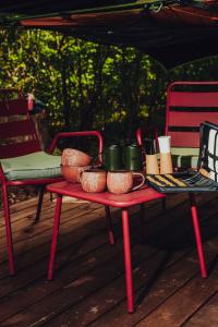 a table with pots and mugs on it on a porch at Dacza Puchacza Hamaki in Stare Osieczno