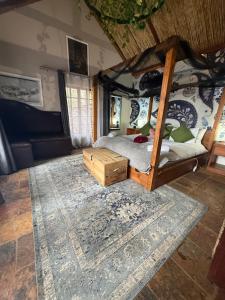 a bedroom with a canopy bed and a rug at Goldeneye Chalet -Hidden Gem of Hartees in Hartbeespoort