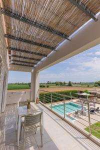 a patio with a table and a view of a pool at Marion Apartments in Kourouta