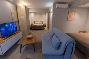a living room with a blue couch and a television at Marion Apartments in Kourouta