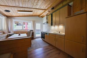 a kitchen with wooden cabinets and a sink and a stove at Appartements Oberdorfer in Landeck