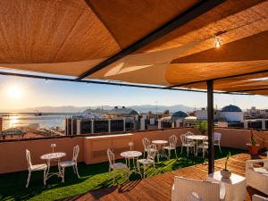 a balcony with tables and chairs and a view of the ocean at My exclusive cavour loft da sogno a cagliari in Cagliari