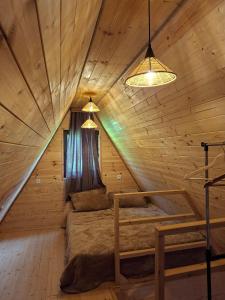 a bedroom in a log cabin with a bed and two lights at WILD NEST Cottage 