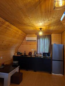 a kitchen with a refrigerator in a wooden room at WILD NEST Cottage 