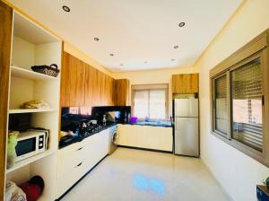 a kitchen with a refrigerator and a microwave at Villa Marrakech Rouge in Aït Zat