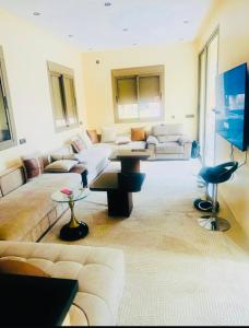 a living room with a couch and a table at Villa Marrakech Rouge in Aït Zat