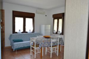 a kitchen and dining room with a table and a couch at il nido in Capoterra