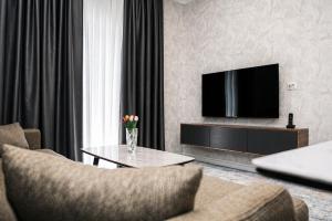 a living room with a television and a coffee table at Delmar Boutique Buzovna in Mekhrably